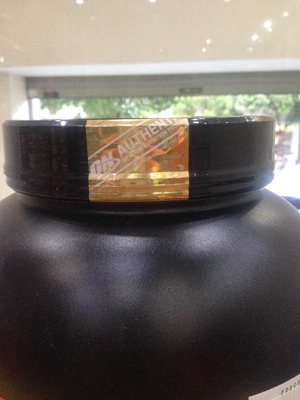 The lid of the 100% Gold Standard Whey jar has a gold hologram stamp on the lid of the box.